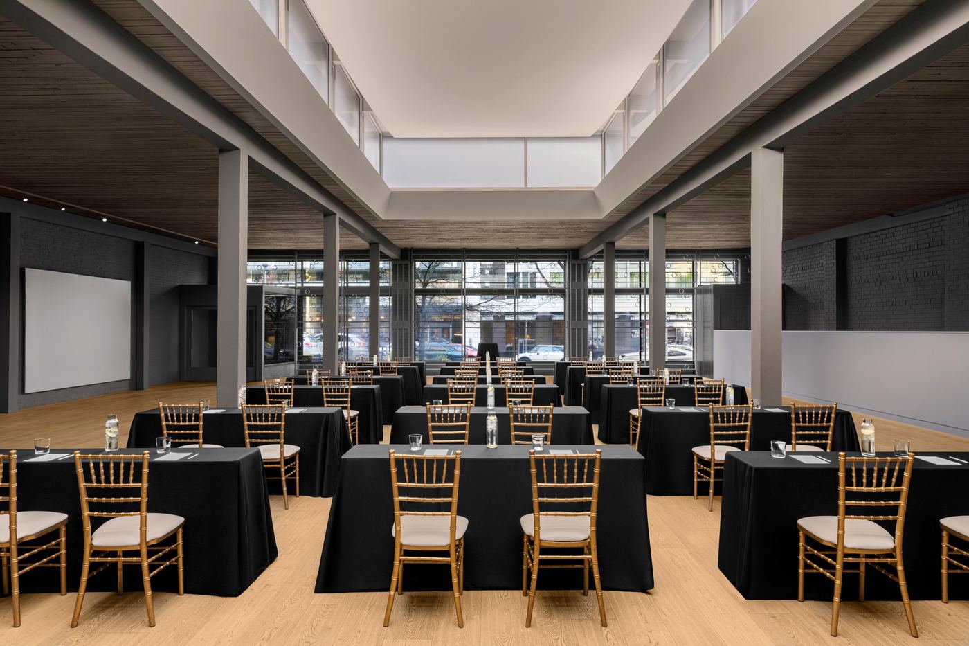Palladian Arthouse main hall set for a corporate conference with black linen tables and gold chiavari chairs
