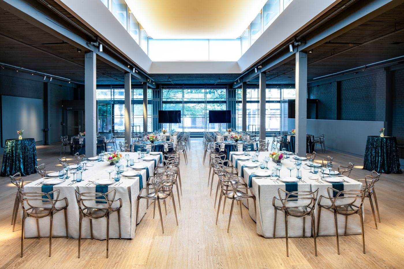 Palladian Arthouse main hall set for a wedding reception with long white linen banquet tables and ghost chairs