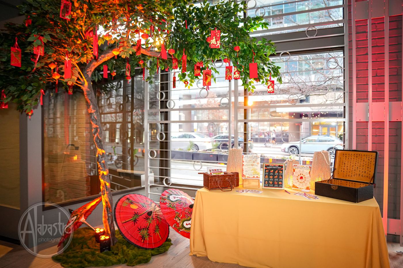 Themed event decor at Palladian Arthouse with decorative tree, red lanterns and parasols